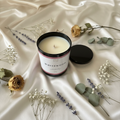 Whitewood candle on silky tablecloth with dried flowers